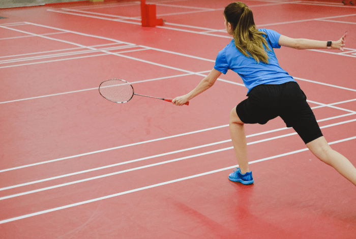 Person hitting a shuttlecock with a badminton racquet