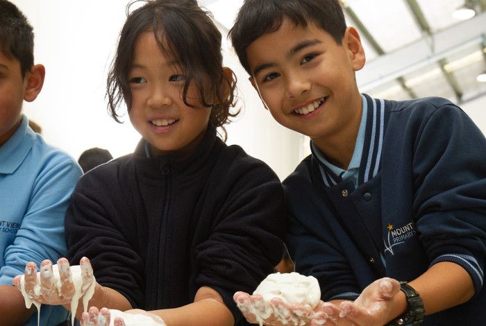 Three children engaged in science experiment.
