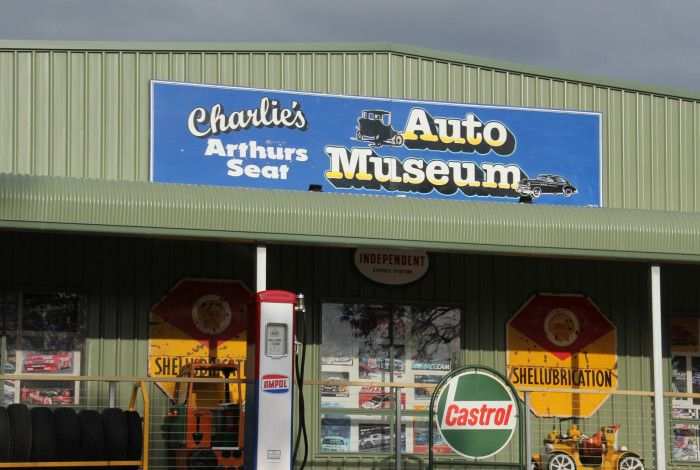 A sign on the front of the building advertising Charlie's Auto Museum