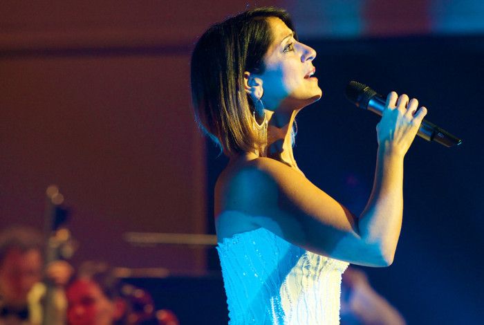 Silvie Paladino A lady holding a microphone and singing