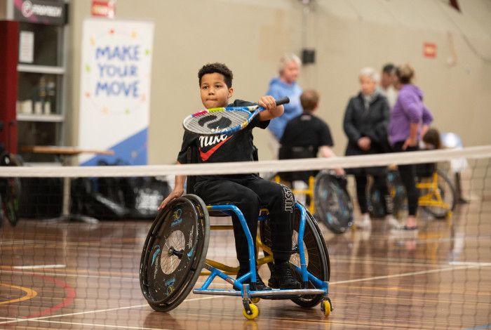Boy in wheelchair playing tennis