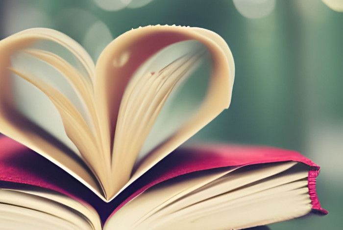 Open book with pages folded in the shape of a love heart.
