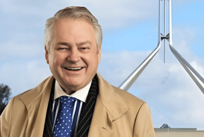 Photo of Dr Keith Sutter standing infront of Parliment House in Camberra