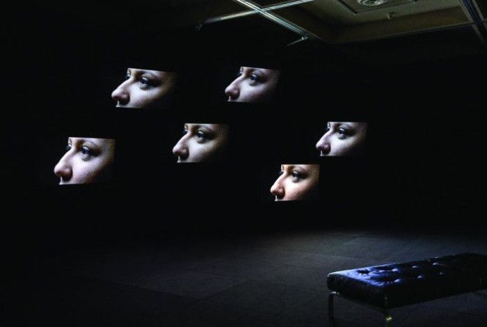 Abstract image of six faces and a couch