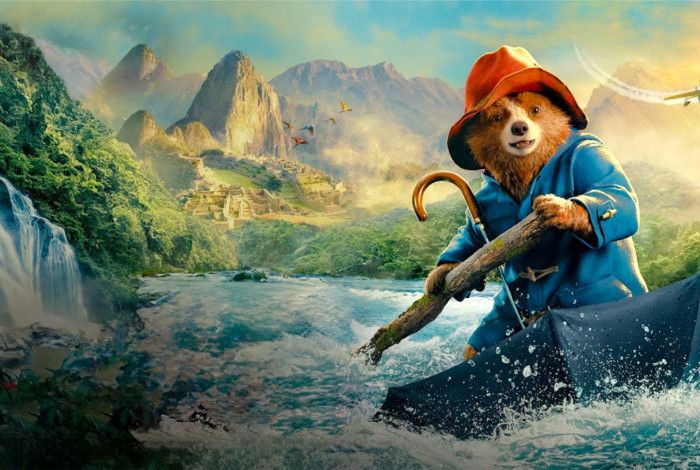 Paddington Bear white water rafting down a river in his umbrella