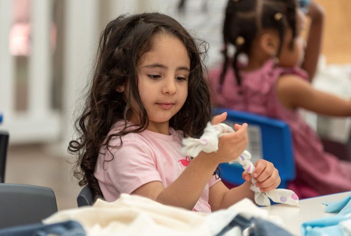 Child making a pet toy out of fabric.
