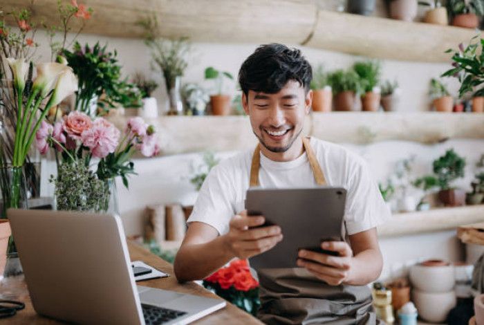business owner in shop looking at ipad