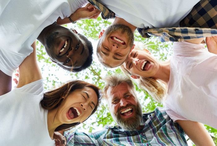 Group of five people laughing in a circle