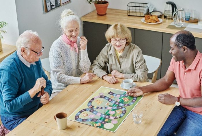 Group of people at a table playing a board game.