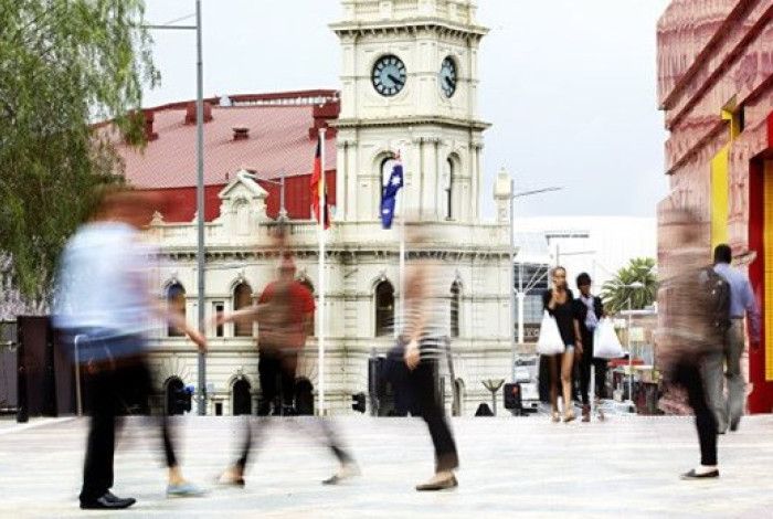 people walking in Dandenong with drum thearte in thebackground
