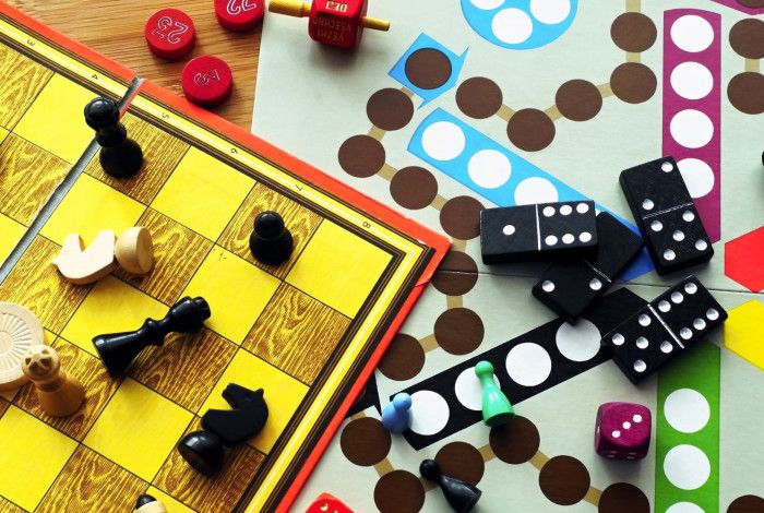 Various board games with game pieces on a table.