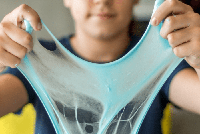 child holding up slime.