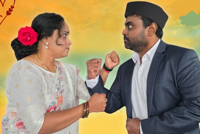 A lady and a man with their fists in the air