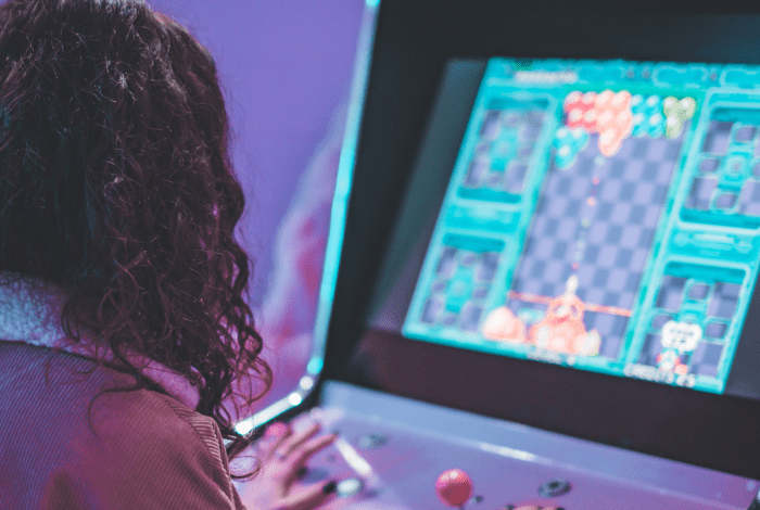 Person playing a video arcade game.