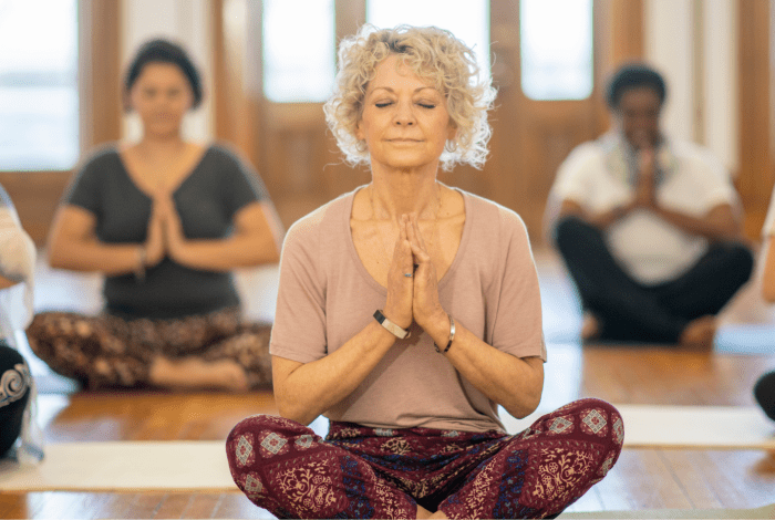 A group of women sitting on the floor doing yoga.