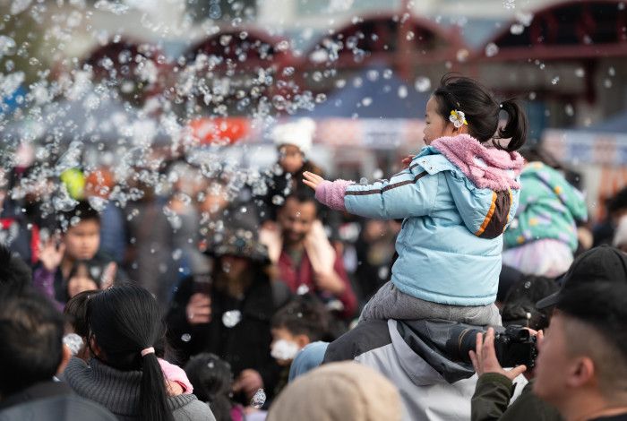 Crowd of people enjoying bubble performance 