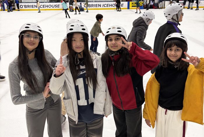 group of young people smiling at ice skating