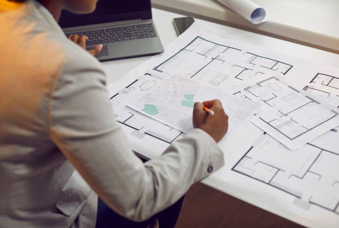 Person making changes to a plan on a table