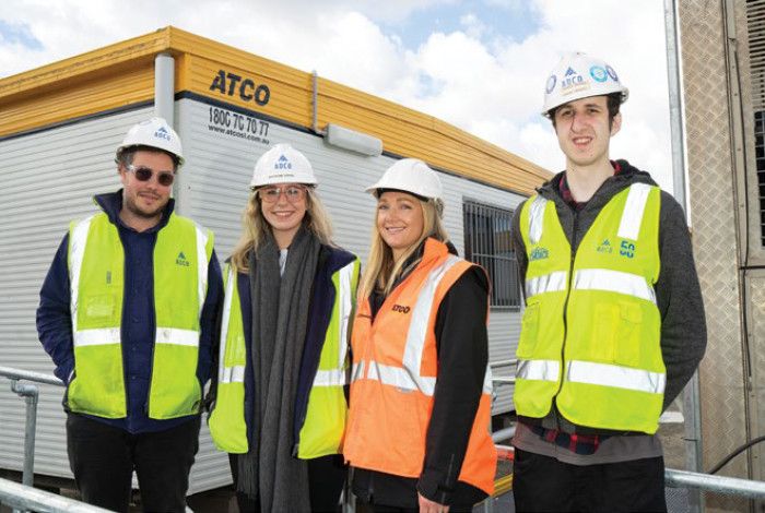 Four people smiling in visy vests