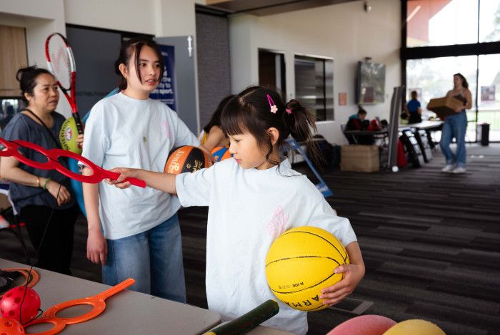 Child sifting through sports equipment