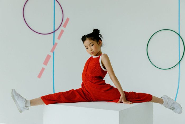 A girl doing gymnastic wearing red clothes.