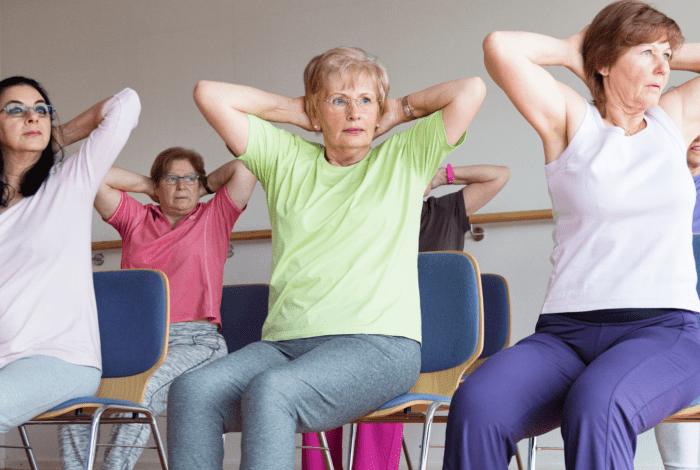Older adults participating in a seated chair yoga class.