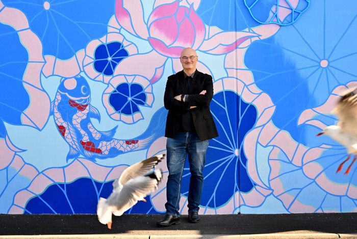 Cr Sean O'Reilly standing in front of a mural