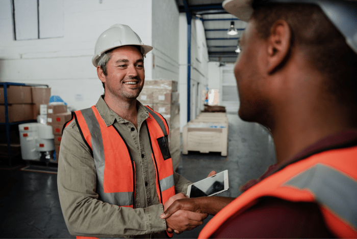 Two workers wearing safety gear at a worksite