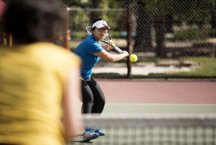 Women hitting a tennis ball with a tennis racquet