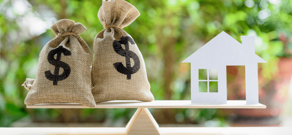 two bags of money and cutout house