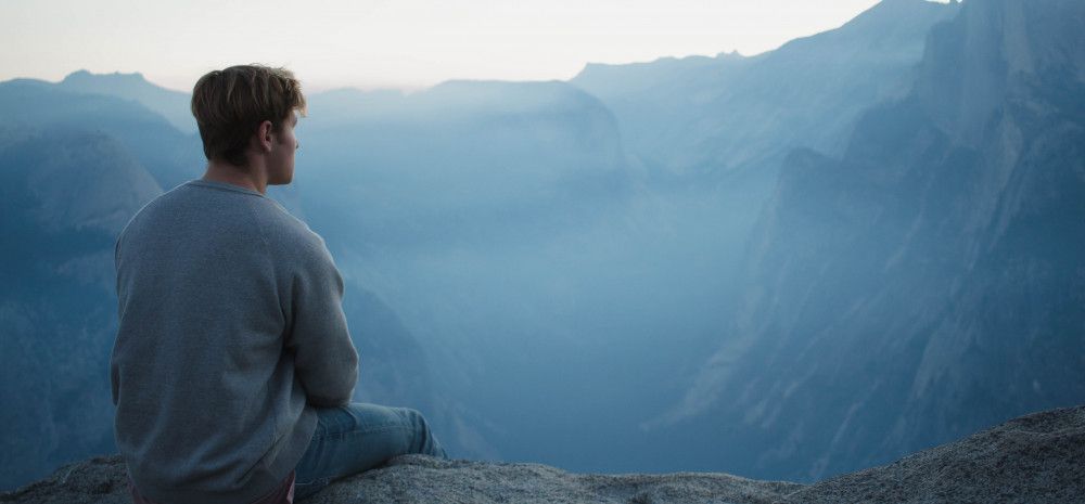 A person meditating in the mountains.