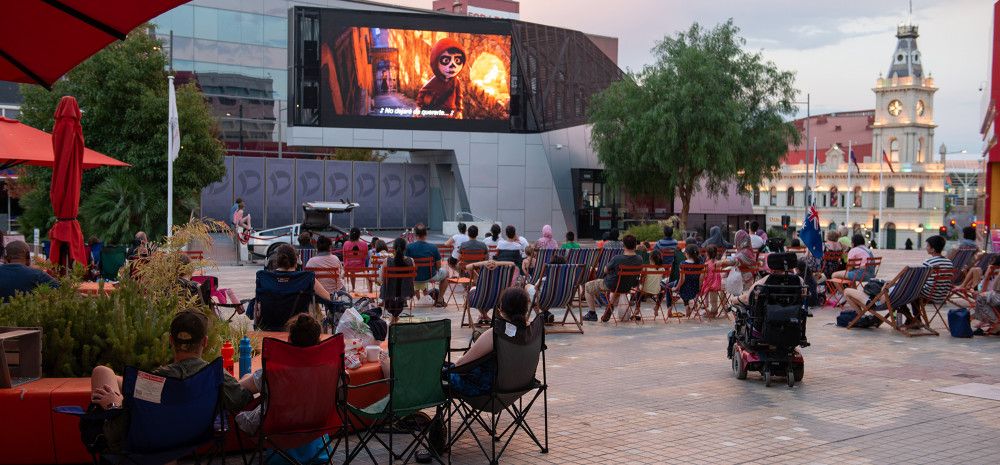 Community members watching a film in Harmony Square