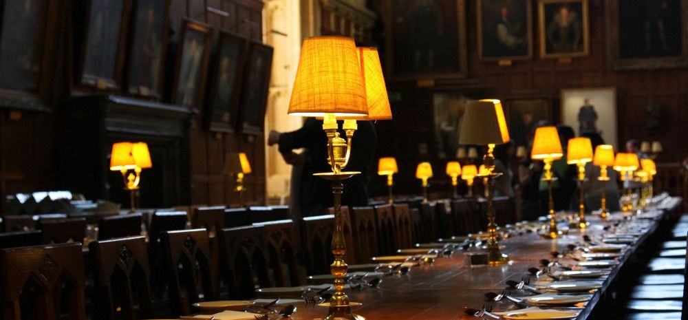many table lights are in a dark dining hall