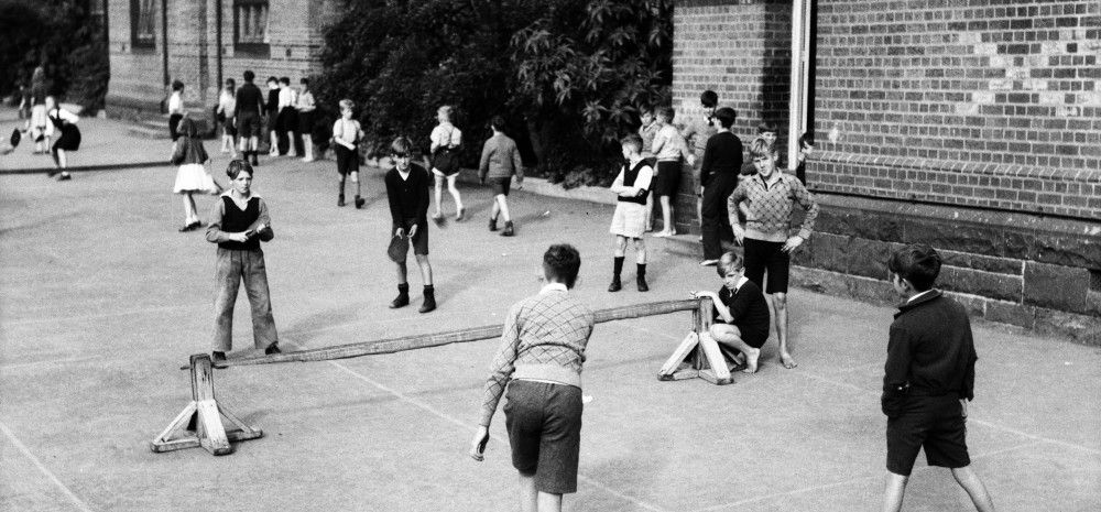 Black and white image of students playing in a school playground
