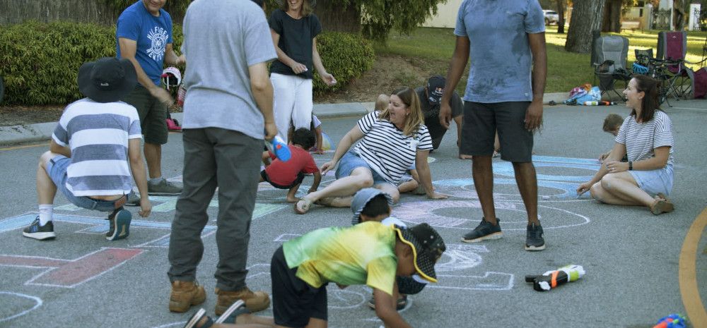 Children and parents drawing on a pavement