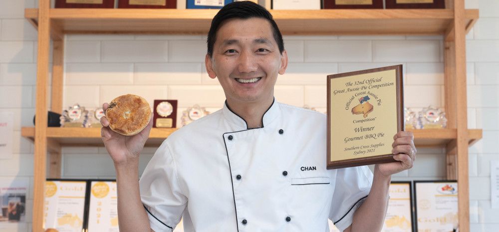 Man holding an award and a pie