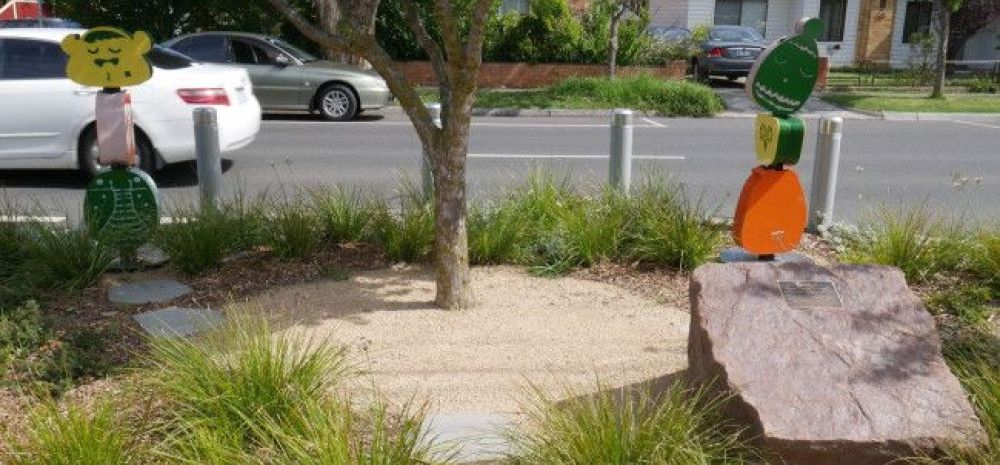 a tree on the nature strip of a street