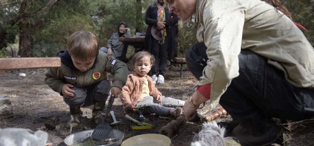 an adult playing outdoors with children