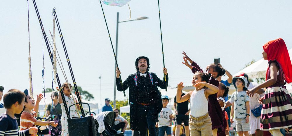 Performer blowing bubbles with children