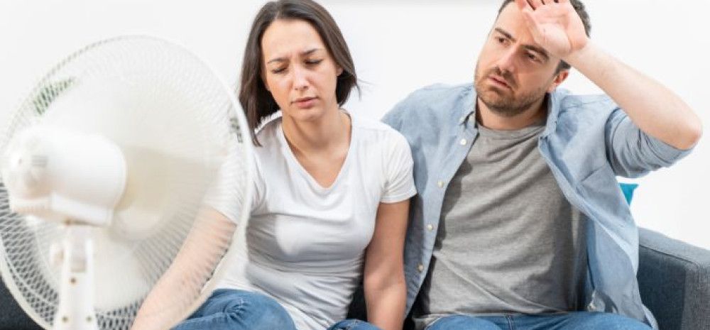 two people sitting in front of a fan