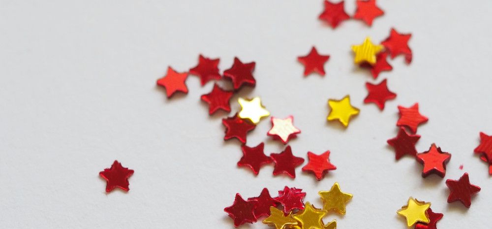 Gold and red glitter stars on a white background