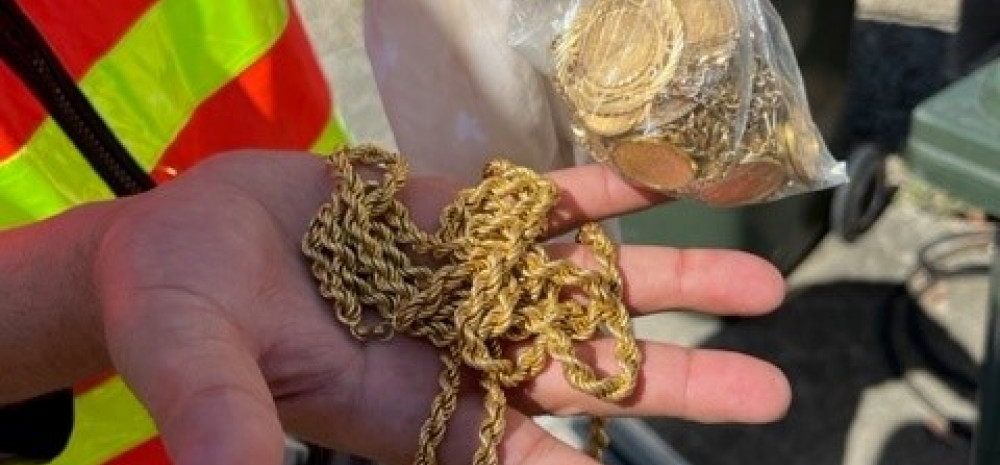 a person holding a gold necklace 