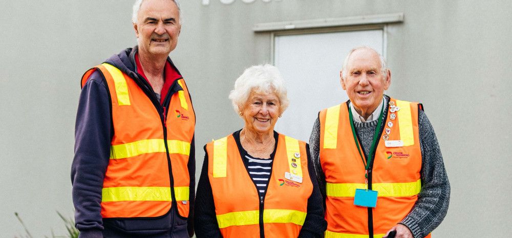 Three Meals on Wheels volunteers dressed in hi-vis vests