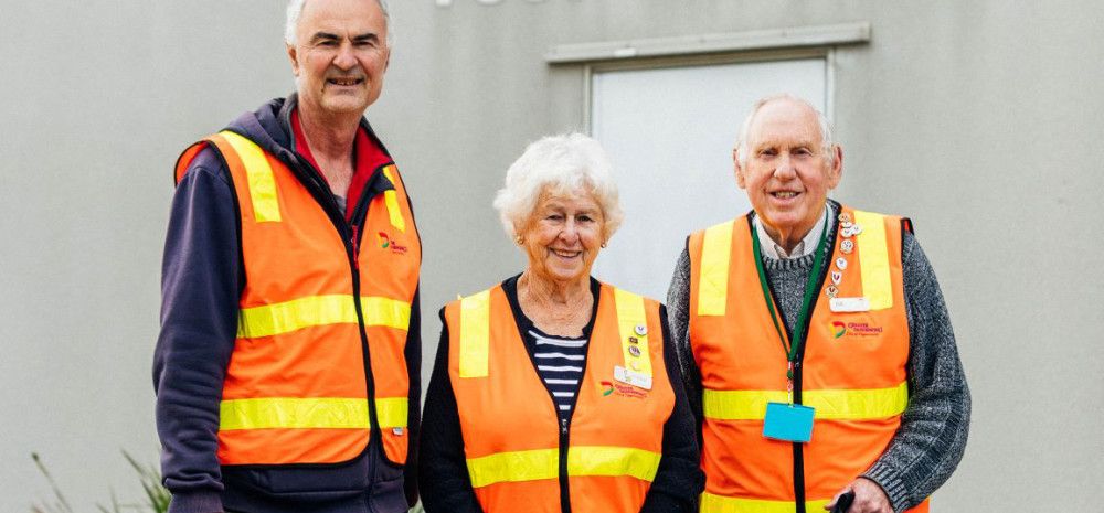 Three Meals on Wheels volunteers dressed in high-vis vests