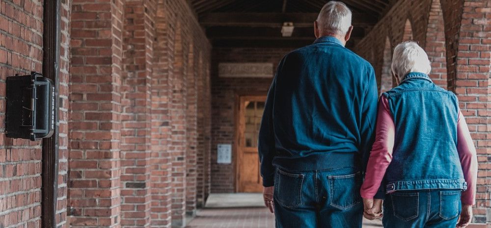Two older people walking together