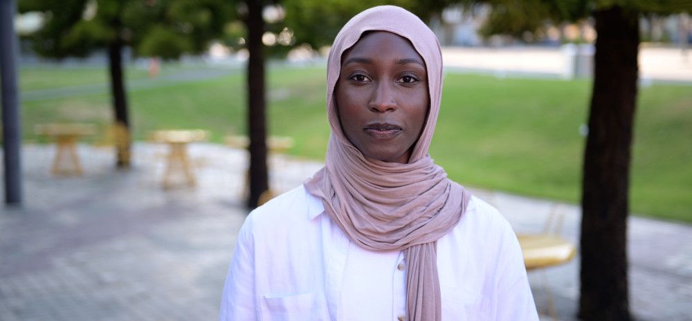 Portrait of Danya Daoud in a pink headscarf and white top.