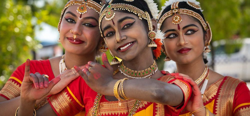 Three women in bright, traditional Indian dress.