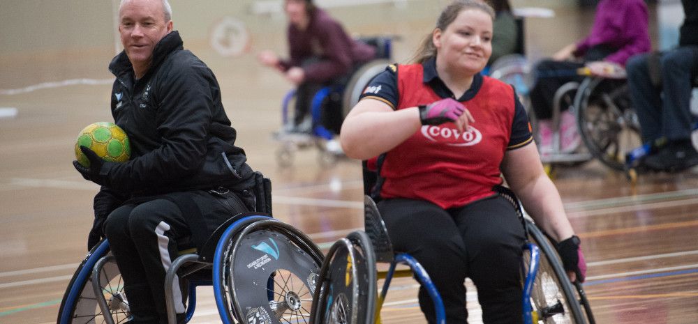 Two people in wheelchairs playing sport