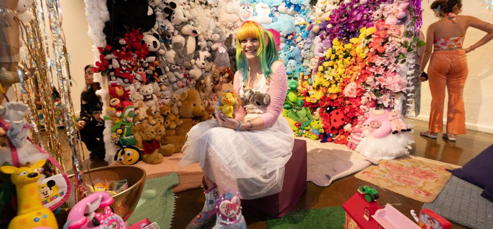 The Opening Event of  A Tra$shy Dreamland - Artist Moon Girle is sitting inside of the installation
