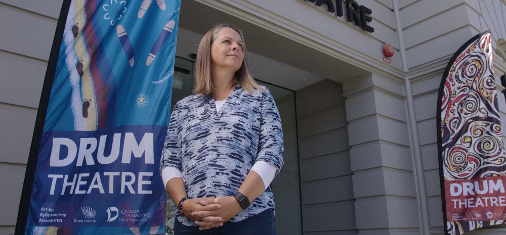 a person standing out front of Drum theatre